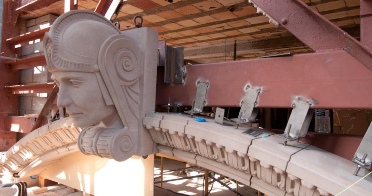 Cast stone keystone bust during installation on commercial facade